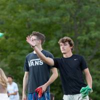 students playing cornhole and tossing green beanbag during Laker Kickoff